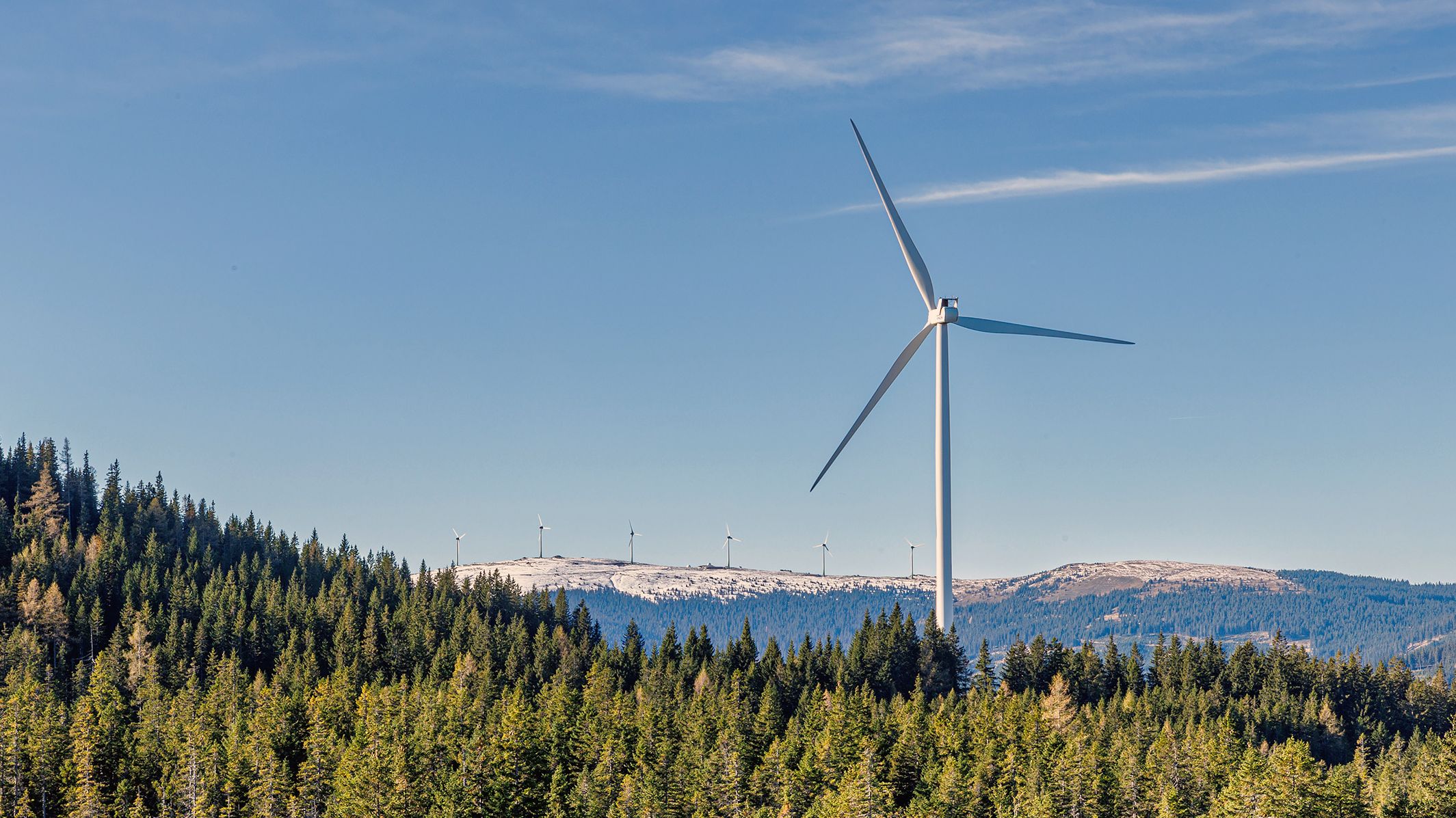 Berglandschaft mit Wäldern und Windrädern